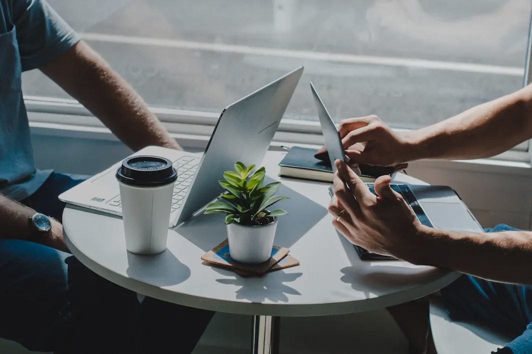 two people having coffee using computers